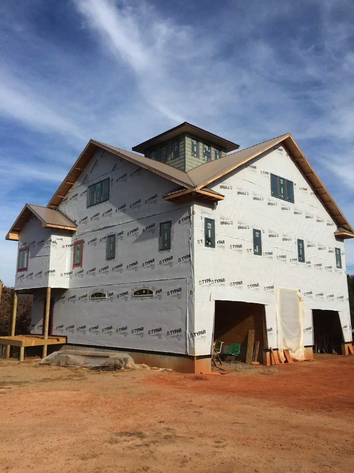 New two story house under construction with a cupola and gabled roofs in Mendon